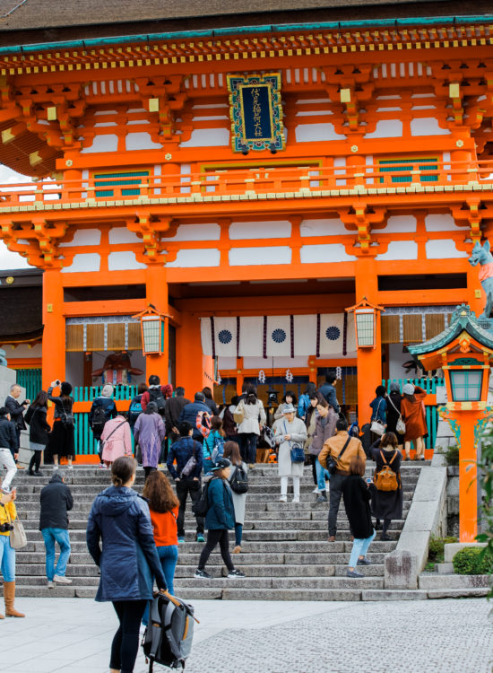 Travel blogger stands in front of Japanese shrine in Kyoto