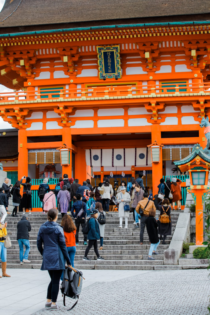 Travel blogger stands in front of Japanese shrine in Kyoto