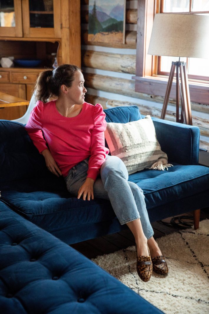 Girl on blue velvet couch wearing Sarah Flint shoes