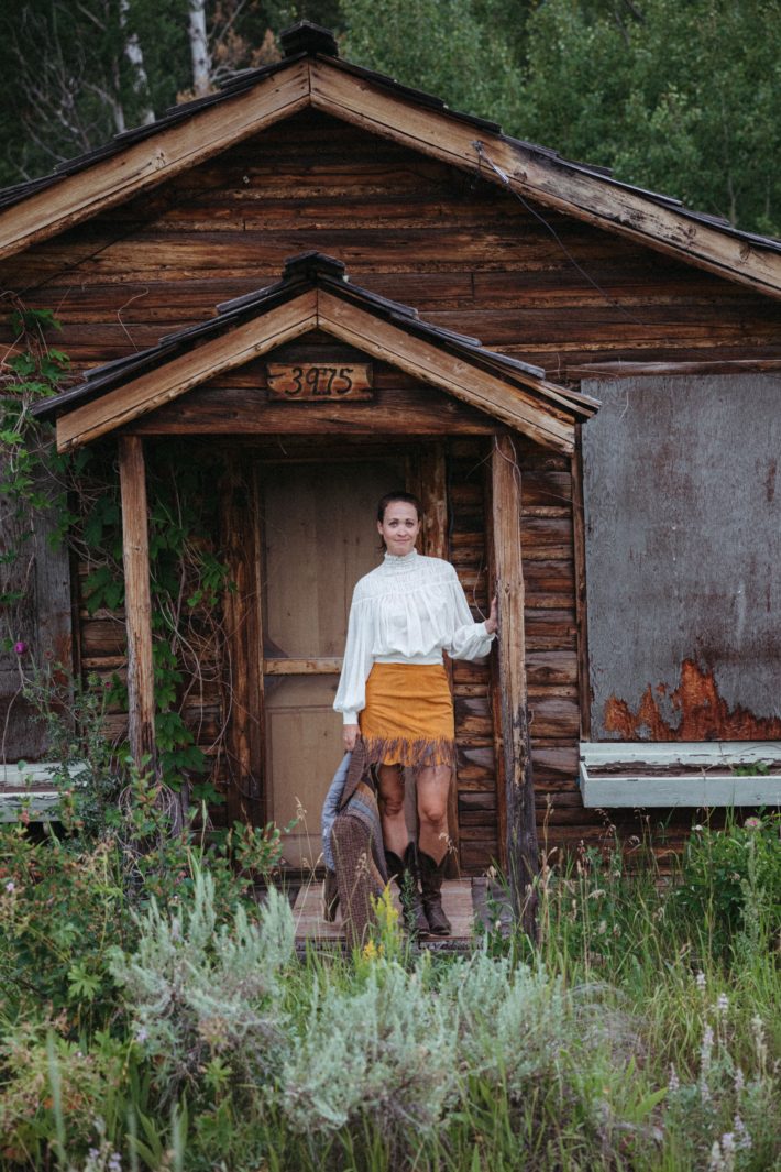 jackson hole blogger in front of log cabin