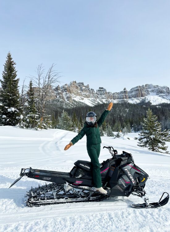 girl in halfdays ski wear snowmobiling at brooks lake lodge and spa